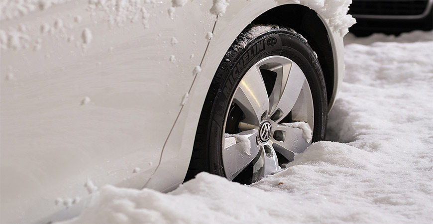 Close up of car tire stuck in snow